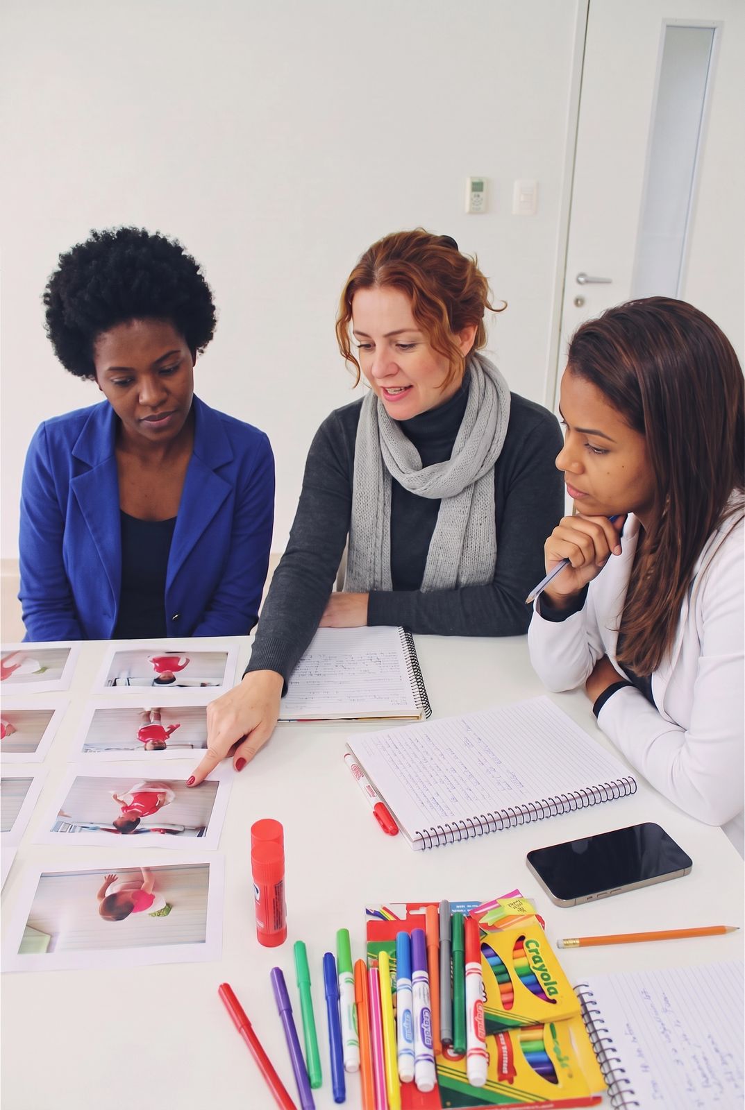 Educadoras em formação analisando registros pedagógicos em mesa